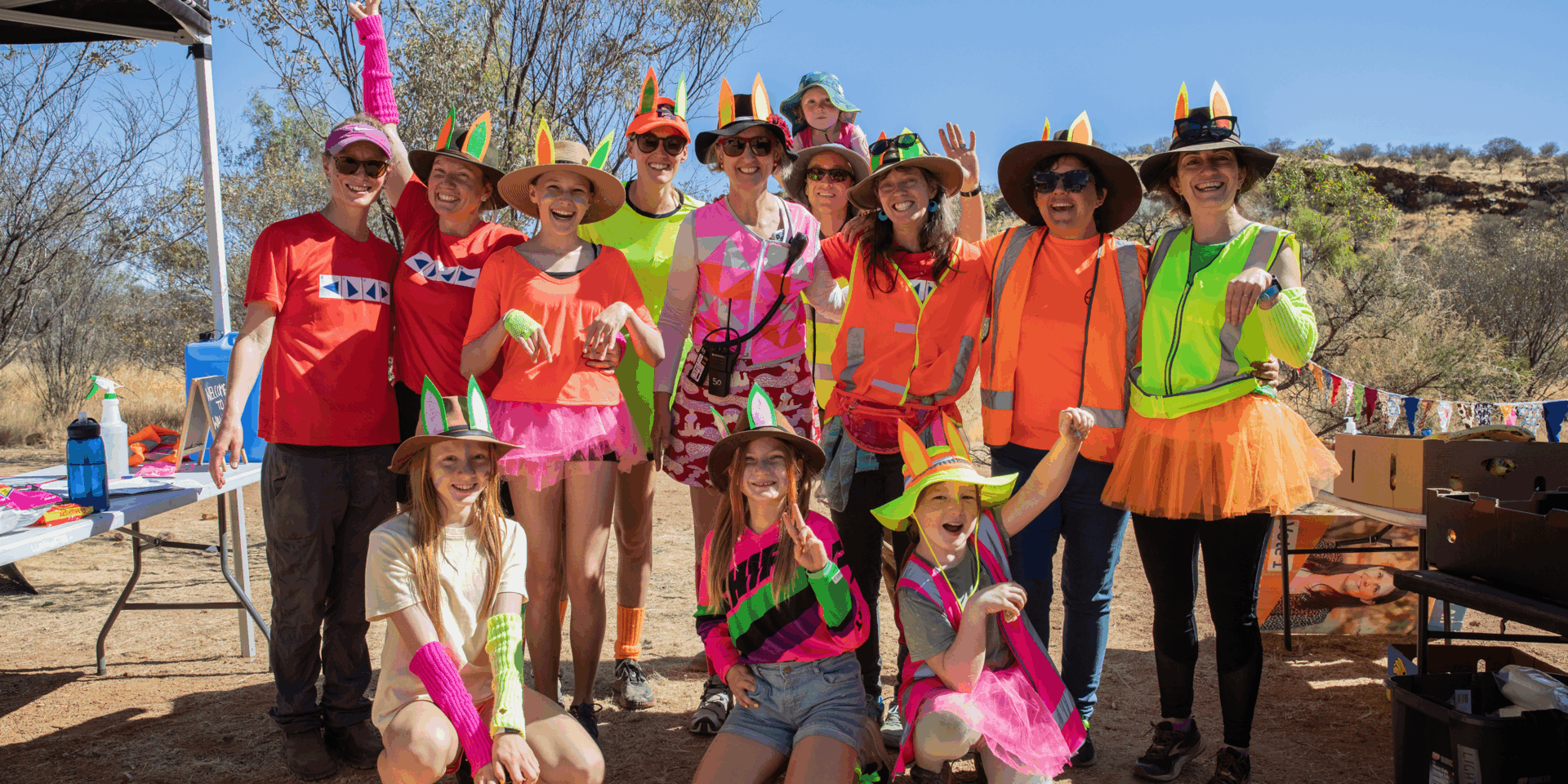 Group in colorful outfits with hats outdoors.