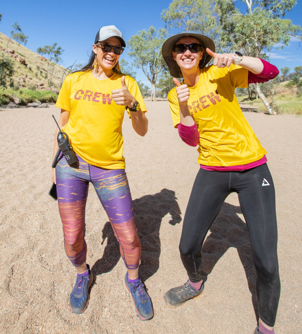 Two people smiling, wearing yellow "CREW" shirts.