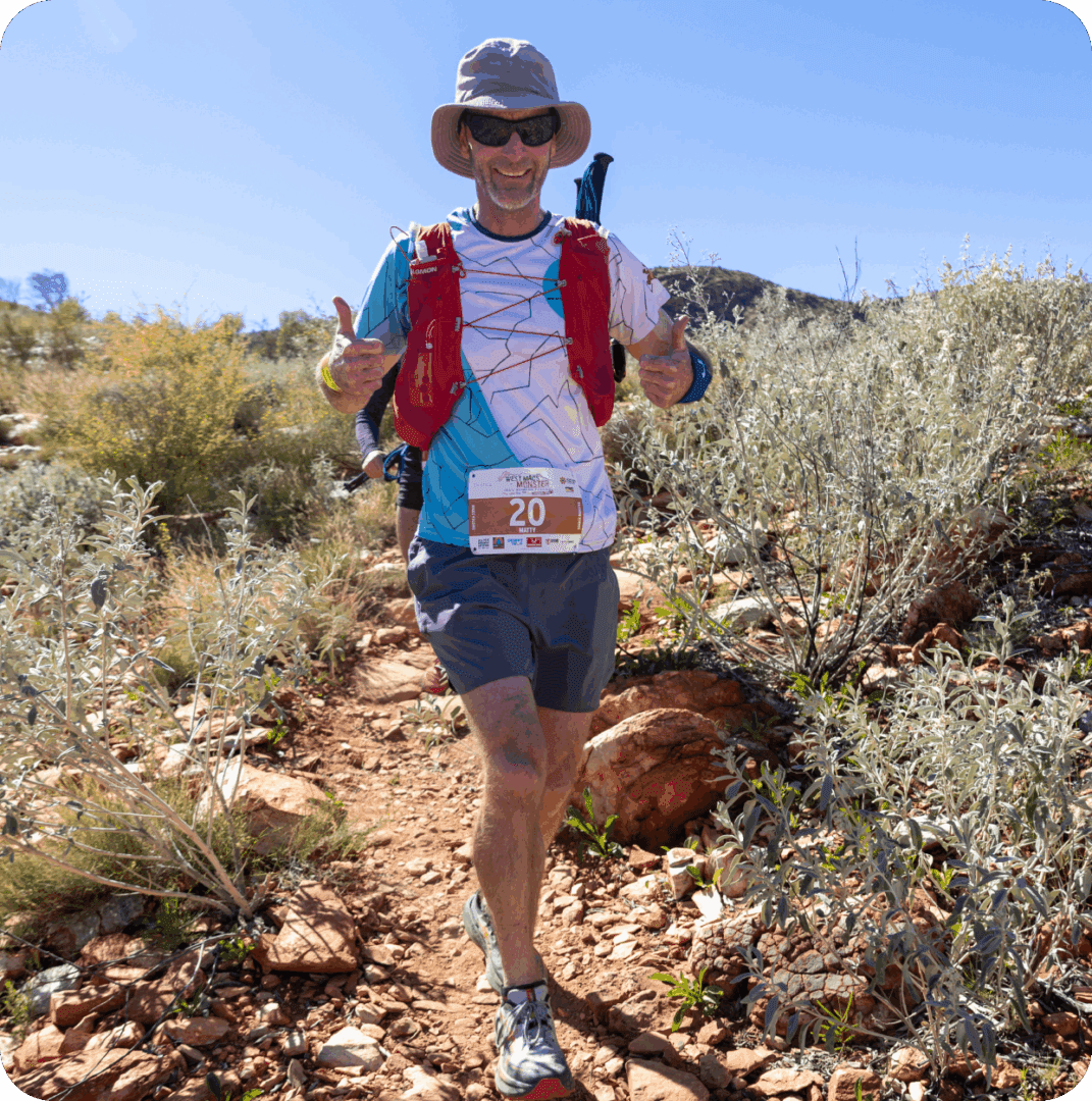 Runner giving thumbs up on rocky trail.